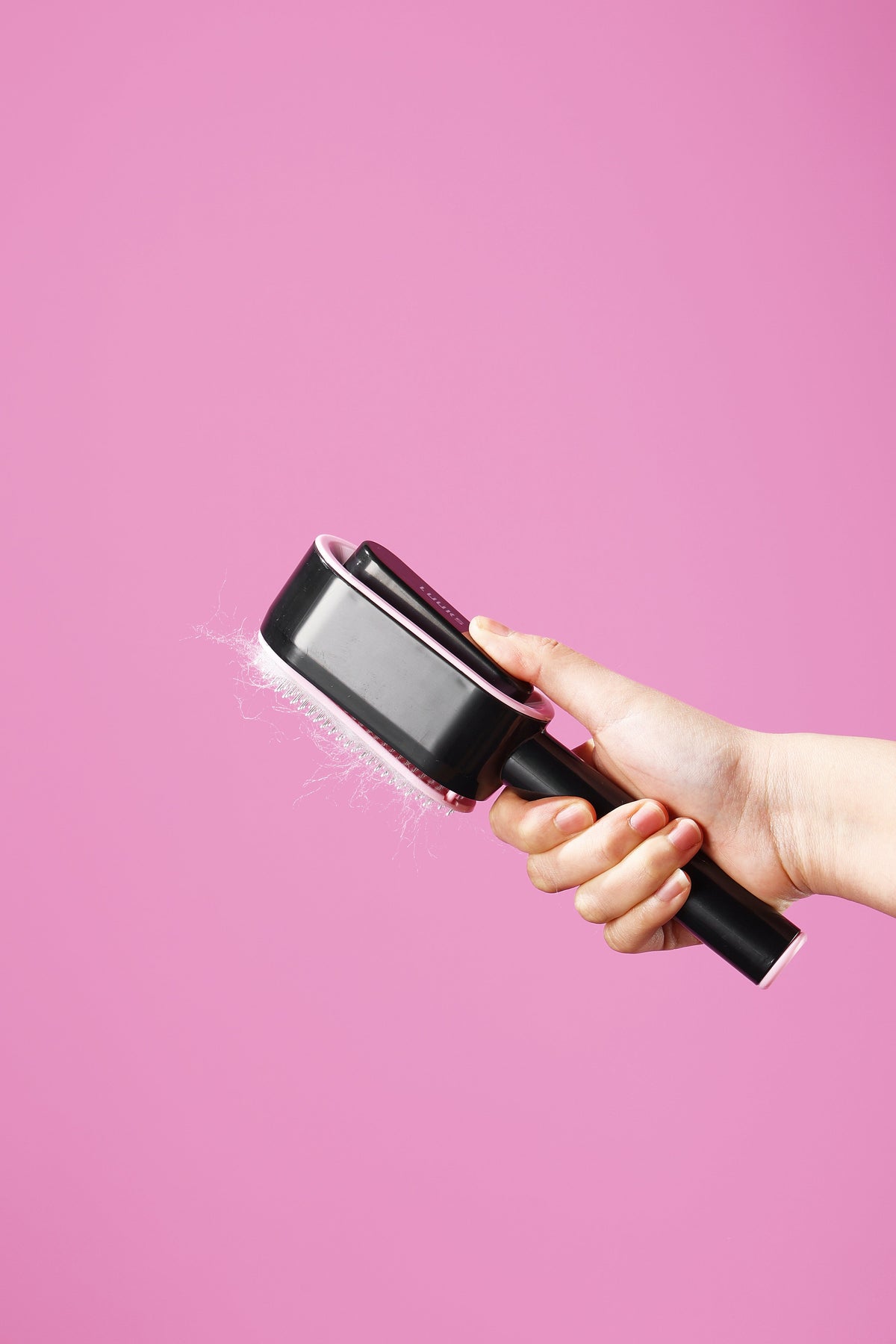 Push-button pet brush grooming a pet